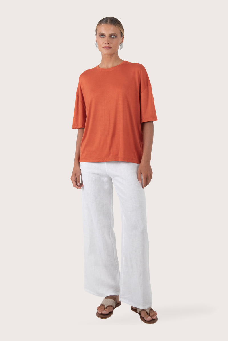 Front view of the Yara Top Orange showcasing its silhouette and relaxed fit.