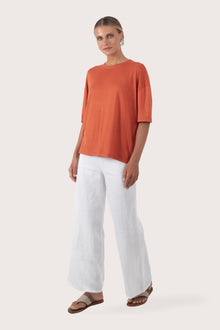 Side profile of the Yara Top Orange showing its cut and natural movement.
