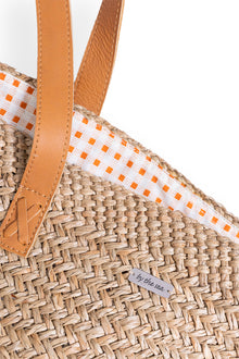 Angled view of the Natural Straw Tote Bag revealing its refined construction and elegant details